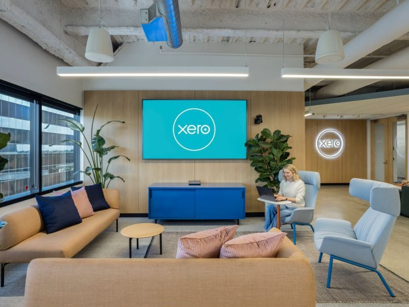 A Xero team member works on her laptop while sitting in a workspace in the company’s office